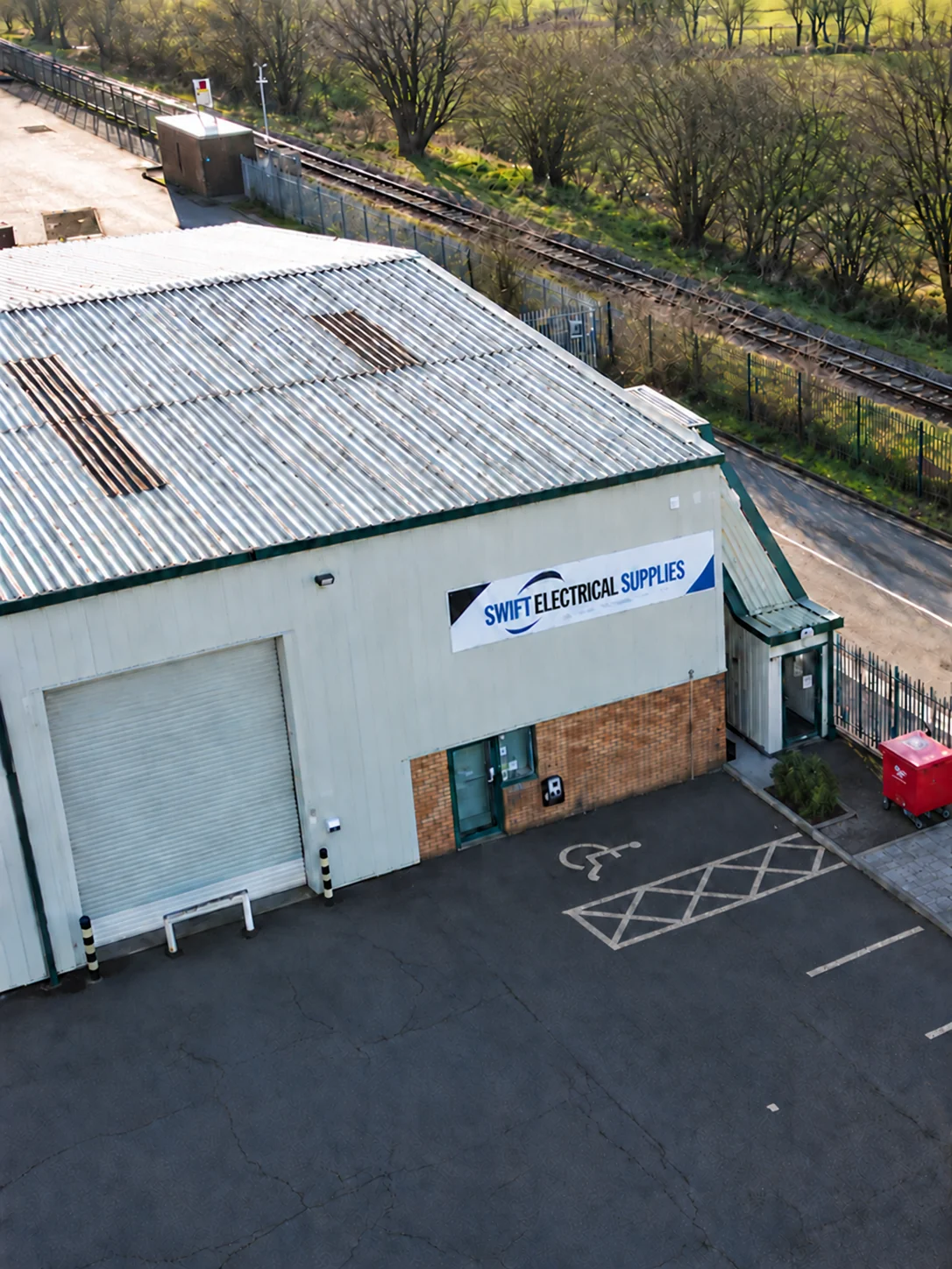Swift Electrical Supplies premises in Heywood, showing the signed building, shutter and entrance